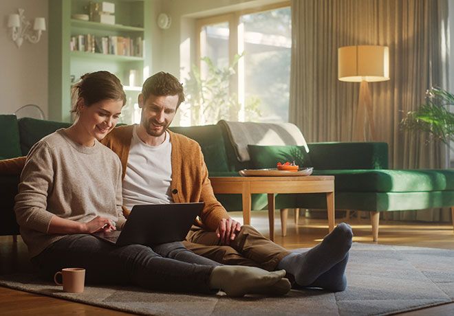 Happy couple on laptop availing of SEAI grants