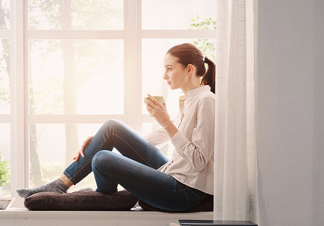 Woman enjoying a cuppa at a window