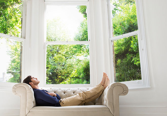Fineo - man relaxing in front of timber sash windows