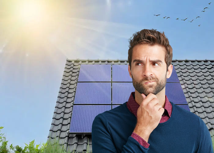 Man Thinking in front of solar panels